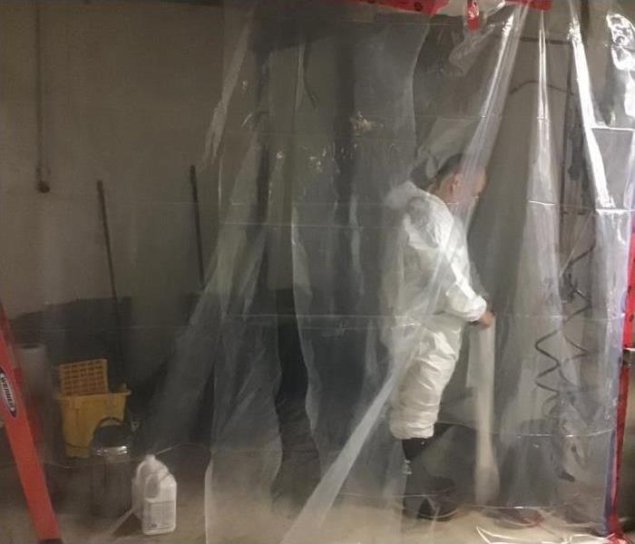 Technician in the containment chamber of a mould damaged home